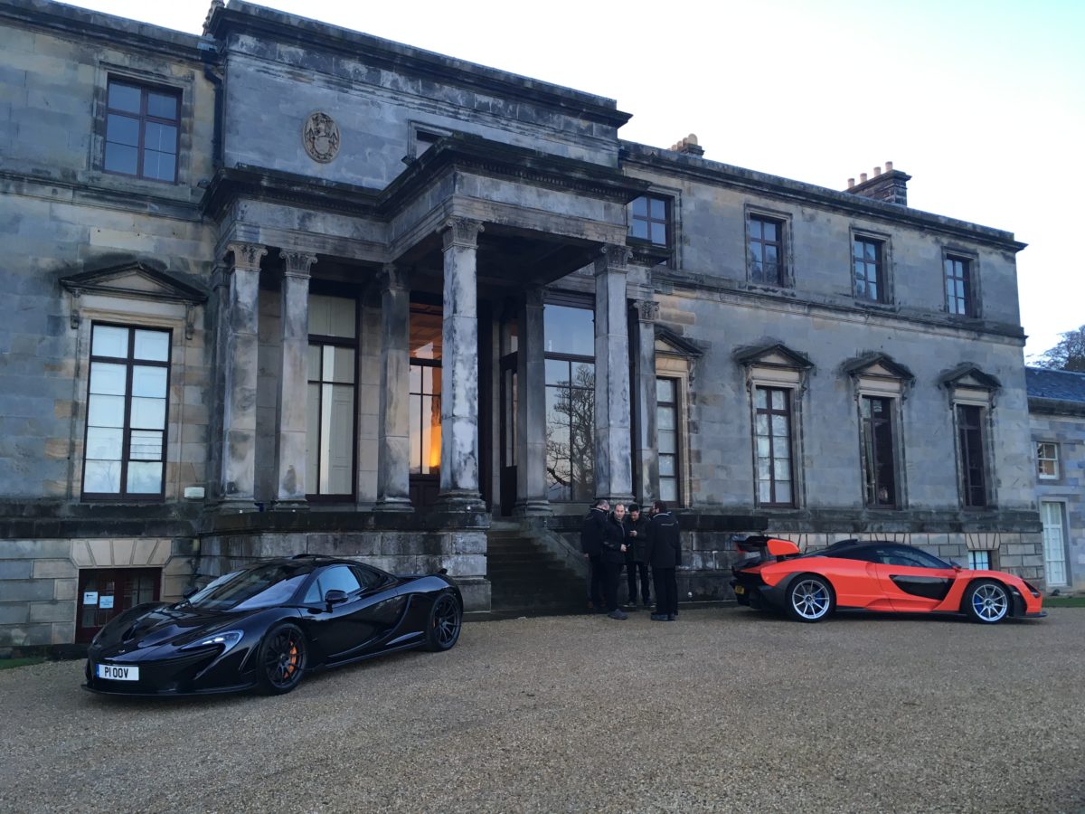 Two supercars outside a country estate